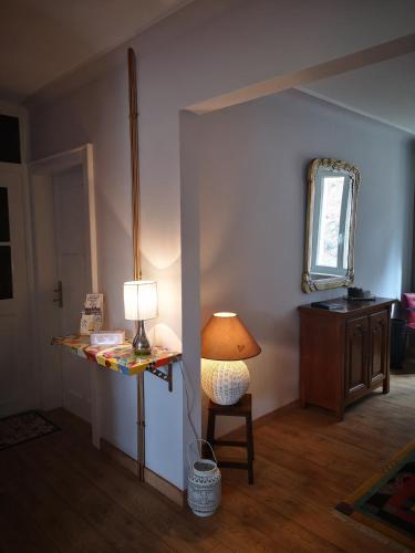 Cette chambre comprend une table avec une lampe et une chaise. dans l'établissement Maison au pays du cristal, à Reyersviller
