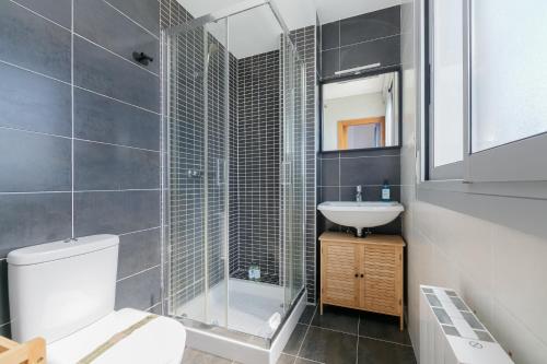 a bathroom with a shower and a toilet and a sink at Con parking y vistas al mar by CABANA Rentals in A Guarda