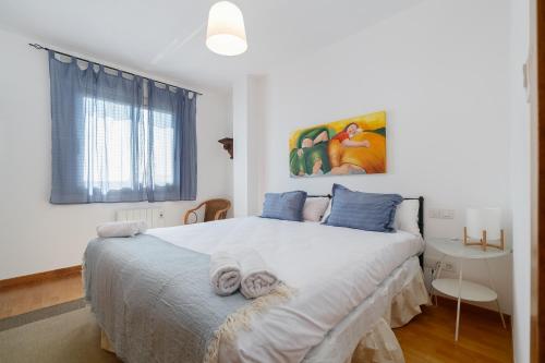 a bedroom with a large bed with towels on it at Con parking y vistas al mar by CABANA Rentals in A Guarda