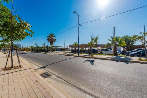an empty street with palm trees and a street light at Sea La Vie Apartment in Golem