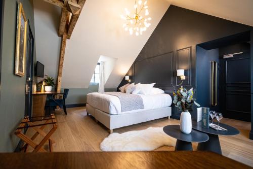 ein Schlafzimmer mit einem Kingsize-Bett und einem Tisch in der Unterkunft Hôtel du cirque et de la cascade in Gavarnie