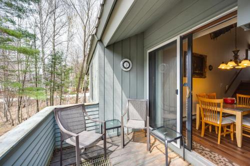 a porch with two chairs and a table on it at Loon Mountain Townhome with Pool and Slope Views! in Lincoln