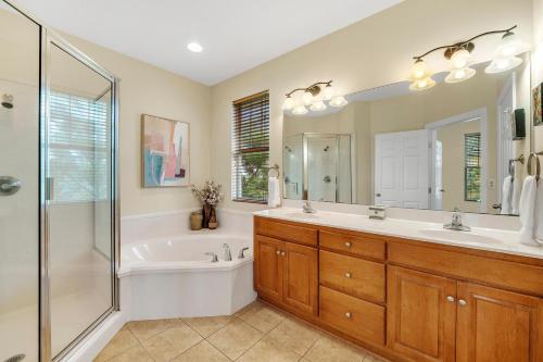 a bathroom with a tub and a sink and a shower at Ambrosia in Gulf Highlands