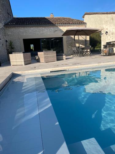 une piscine devant une maison dans l'établissement Villa Fongrive, ferme Périgourdine haut de gamme, à Thénac