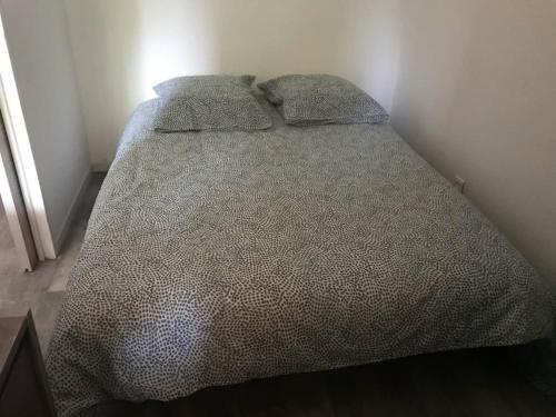 un lit avec deux oreillers dessus dans une chambre dans l'établissement La Faviere T2 4pers RDC avec Terrasse, à Bormes-les-Mimosas