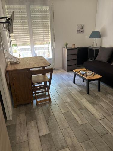 un salon avec un canapé et une table dans l'établissement La Faviere T2 4pers RDC avec Terrasse, à Bormes-les-Mimosas