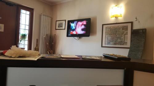 a living room with a tv on the wall at Aurelia Garden Gold B&B in Rome