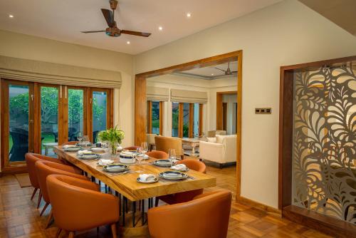 a dining room with a long table and orange chairs at Colombo Villa Collection in Colombo