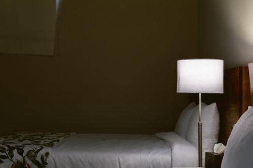a bedroom with a bed and a lamp next to a bed at Casa Xaca in San Miguel de Allende