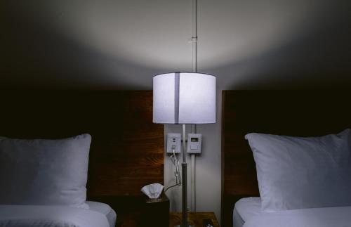 a room with two beds and a lamp in a bedroom at Casa Xaca in San Miguel de Allende