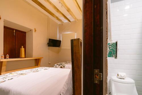 a bedroom with a white bed and a toilet at Casa Xaca in San Miguel de Allende