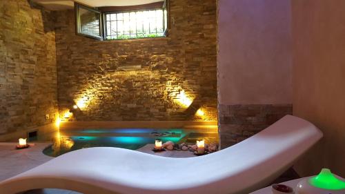 a bath tub in a room with a brick wall at Aurelia Garden Gold B&B in Rome