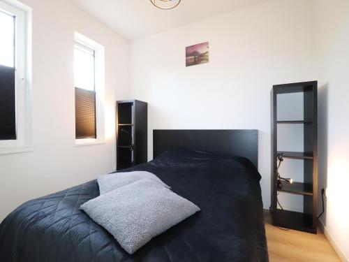a bedroom with a black bed and a window at Scenic Stay with Sauna in Anjum