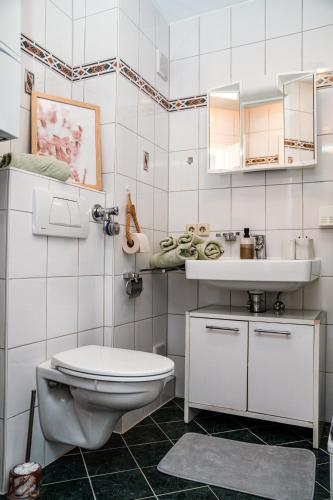 a white bathroom with a toilet and a sink at Ferienwohnung Ella - direkt am Bodensee in Friedrichshafen