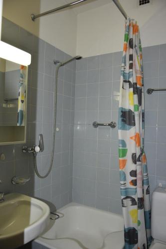 a bathroom with a shower curtain and a sink at Casa Santa Birgitta in Lugano
