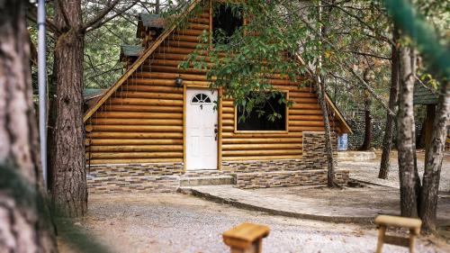 a log cabin with a white door in the woods at Cabañas Rincon del Ángel 1 in Ciénaga