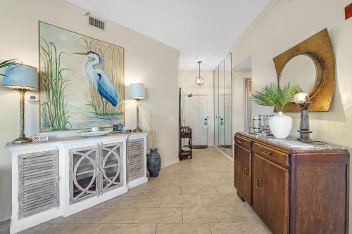 a living room with a blue bird painting on the wall at 301 West in Gulf Highlands