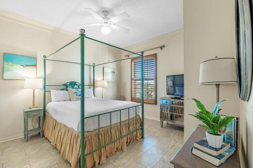 a bedroom with a four poster bed with a fan at 301 West in Gulf Highlands