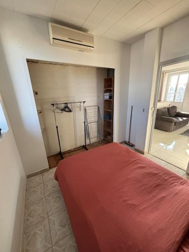 une chambre avec un lit rouge dans une pièce dans l'établissement Appartement proche de la gare et du centre ville, à Valence