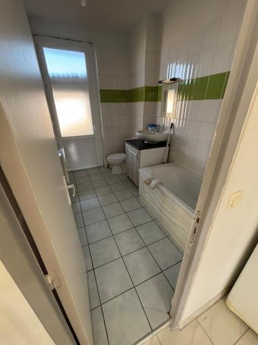 une salle de bain avec une baignoire, des toilettes et un lavabo dans l'établissement Appartement proche de la gare et du centre ville, à Valence