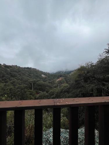 a view of a mountain with clouds in the distance at La Misión Cabañas Chignahuapan in Chignahuapan