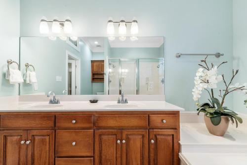 Un baño con lavabo y un espejo grande. en Bonavita, en Gulf Highlands