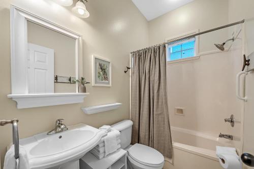 Un baño blanco con lavabo e inodoro. en Beach Haven, en Gulf Highlands