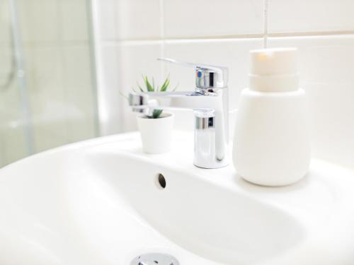 a bathroom sink with a soap dispenser on it at OH KEY Apartments - unlock your stay - Zentral in Fulda-City in Fulda