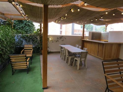 a patio with a table and chairs under an umbrella at HOTEL A & A SANTA ALEJANDRIA in Medellín