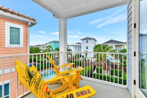 a yellow swing on a balcony with a view of a pool at Margaritaville Cottages Orlando with H2O Waterpark by Rentyl in Kissimmee