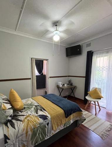 a bedroom with a bed and a tv on the wall at Tanya's Haven Guesthouse in Klerksdorp