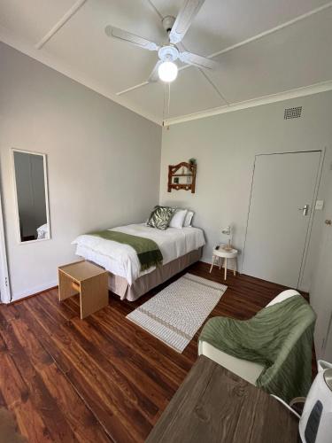 a bedroom with two beds and a ceiling fan at Tanya's Haven Guesthouse in Klerksdorp