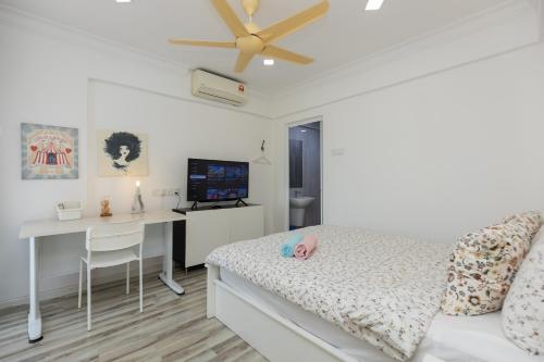 a bedroom with a bed and a desk with a computer at Eastern Apt, Jelutong in Jelutong