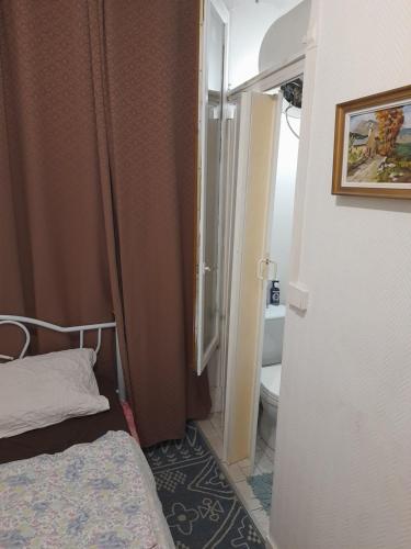 une petite chambre avec un lit et une salle de bain dans l'établissement Studio ab, à Saint-Ouen