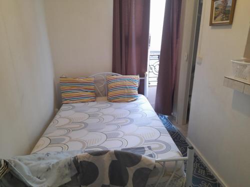 - un petit lit dans une petite chambre avec fenêtre dans l'établissement Studio ab, à Saint-Ouen