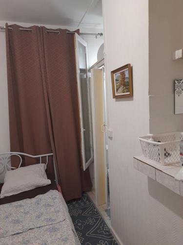 une petite chambre avec un lit et un miroir dans l'établissement Studio ab, à Saint-Ouen