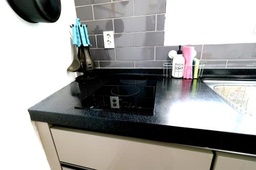 a kitchen with a black counter top and a sink at HAH Guesthouse in Seoul