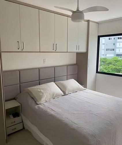 a bedroom with a bed with white cabinets and a window at 2 quartos São Conrado ao lado Hotel Nacional in Rio de Janeiro