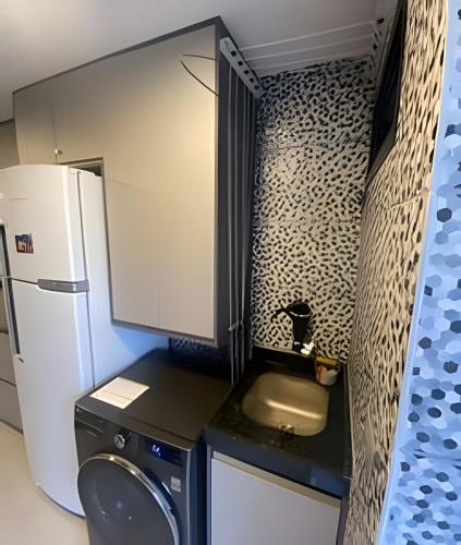 a small kitchen with a sink and a refrigerator at 2 quartos São Conrado ao lado Hotel Nacional in Rio de Janeiro