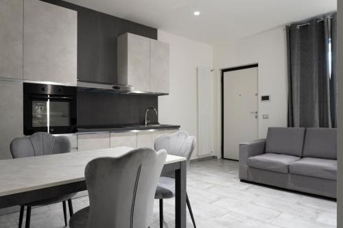 a kitchen with a table and chairs and a couch at Casa Servizi Home in San Secondo Parmense