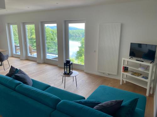 a living room with a blue couch and a television at #2 Ommi Kese Sansibar Apartment Panorama Balkon in Olpe