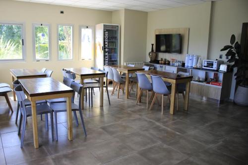 a restaurant with wooden tables and chairs in a room at Alojamiento Traslaviña in Vista Flores