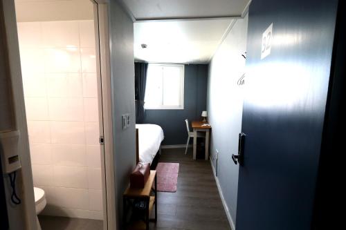 a small room with a bed and a bathroom at HAH Guesthouse in Seoul