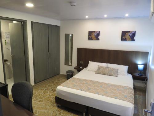 a hotel room with a bed and a desk at HOTEL A & A SANTA ALEJANDRIA in Medellín