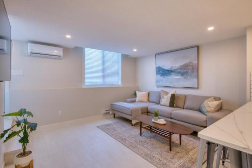 una sala de estar con un sofá y una mesa en Stylish & Comfy Mountain Escape King Bed PS5!, en Calgary