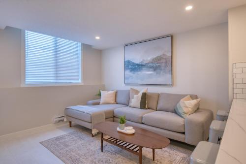 una sala de estar con un sofá y una mesa en Stylish & Comfy Mountain Escape King Bed PS5!, en Calgary