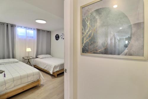 a bedroom with two beds and a painting on the wall at Charming Twin Room & Parking in Saint-Bruno-de-Montarville