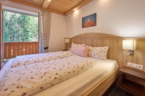 a bedroom with a large bed and a window at Gästehaus Sonnenbichl in Berchtesgaden