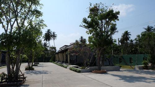 Lullaby Boutique Resort في Thap Sakae: منزل فيه اشجار امام رصيف المشاه