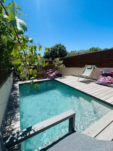 une piscine avec une terrasse et une chaise à l'intérieur dans l'établissement Villa Zanzibar Porto-vecchio, à Porto-Vecchio